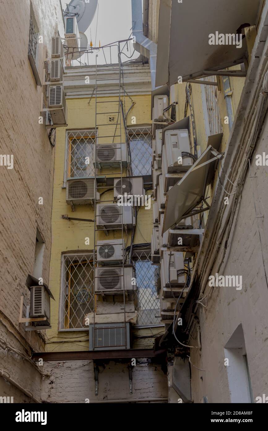Blocchi esterni di condizionatori d'aria situati nel cortile della casa. Un ambiente urbano moderno in uno sviluppo del diciannovesimo secolo. Foto Stock