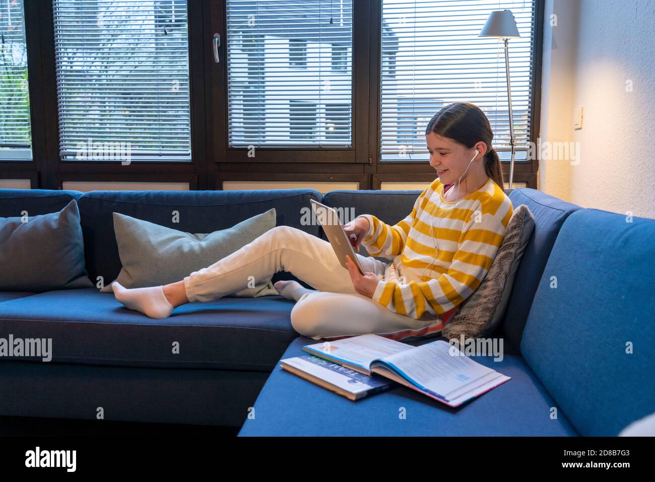 Homeschooling, ragazza, 11 anni, imparare a casa, apprendimento a casa, lezioni a casa, apprendimento a distanza, chat con insegnanti e compagni di classe via tablet P. Foto Stock
