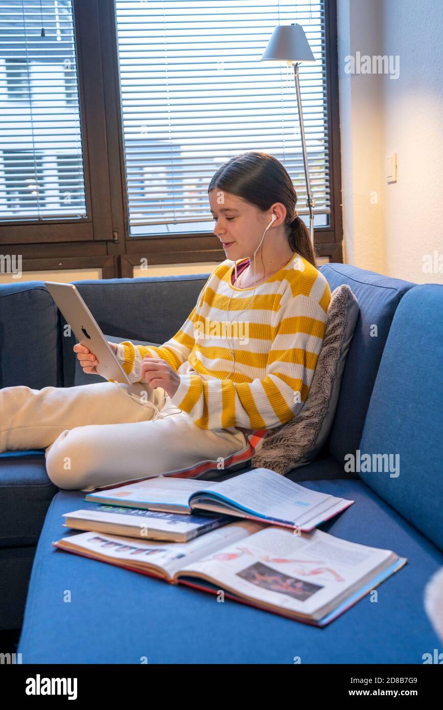Homeschooling, ragazza, 11 anni, imparare a casa, apprendimento a casa, lezioni a casa, apprendimento a distanza, chat con insegnanti e compagni di classe via tablet P. Foto Stock