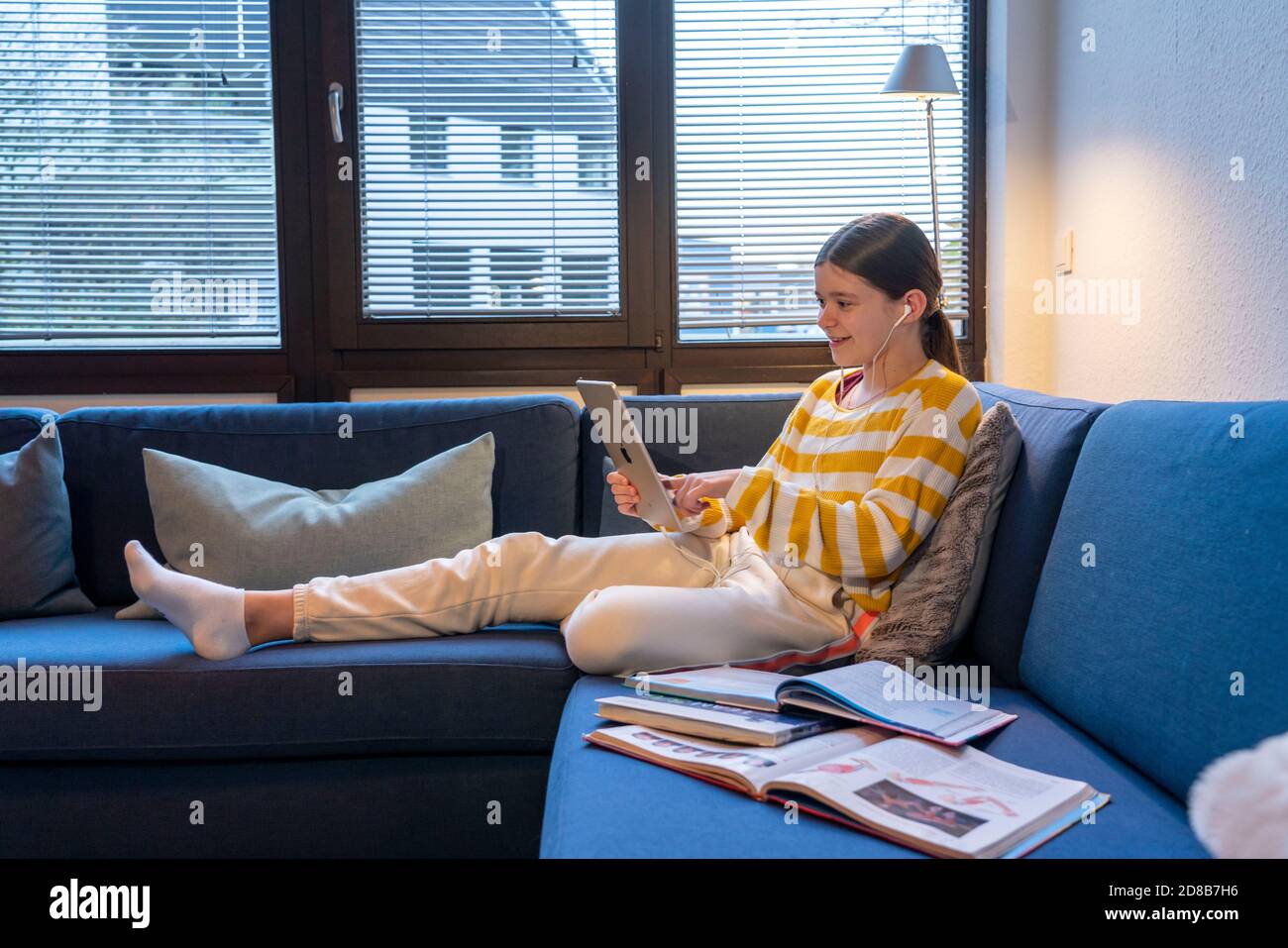 Homeschooling, ragazza, 11 anni, imparare a casa, apprendimento a casa, lezioni a casa, apprendimento a distanza, chat con insegnanti e compagni di classe via tablet P. Foto Stock