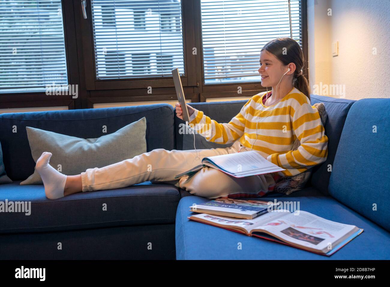 Homeschooling, ragazza, 11 anni, imparare a casa, apprendimento a casa, lezioni a casa, apprendimento a distanza, chat con insegnanti e compagni di classe via tablet P. Foto Stock