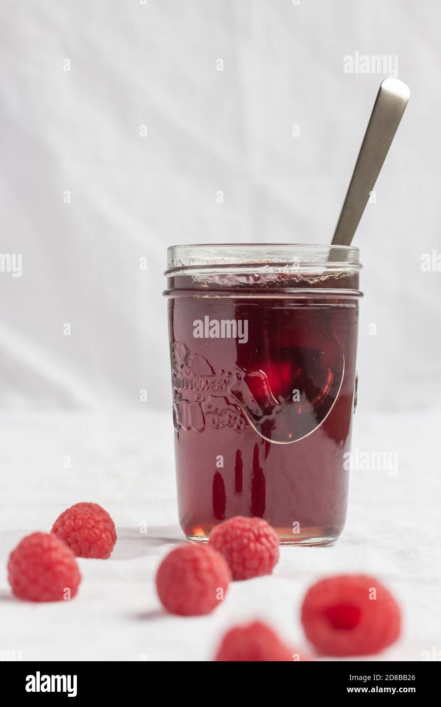 Vasetto di gelatina di lampone e lamponi freschi Foto Stock