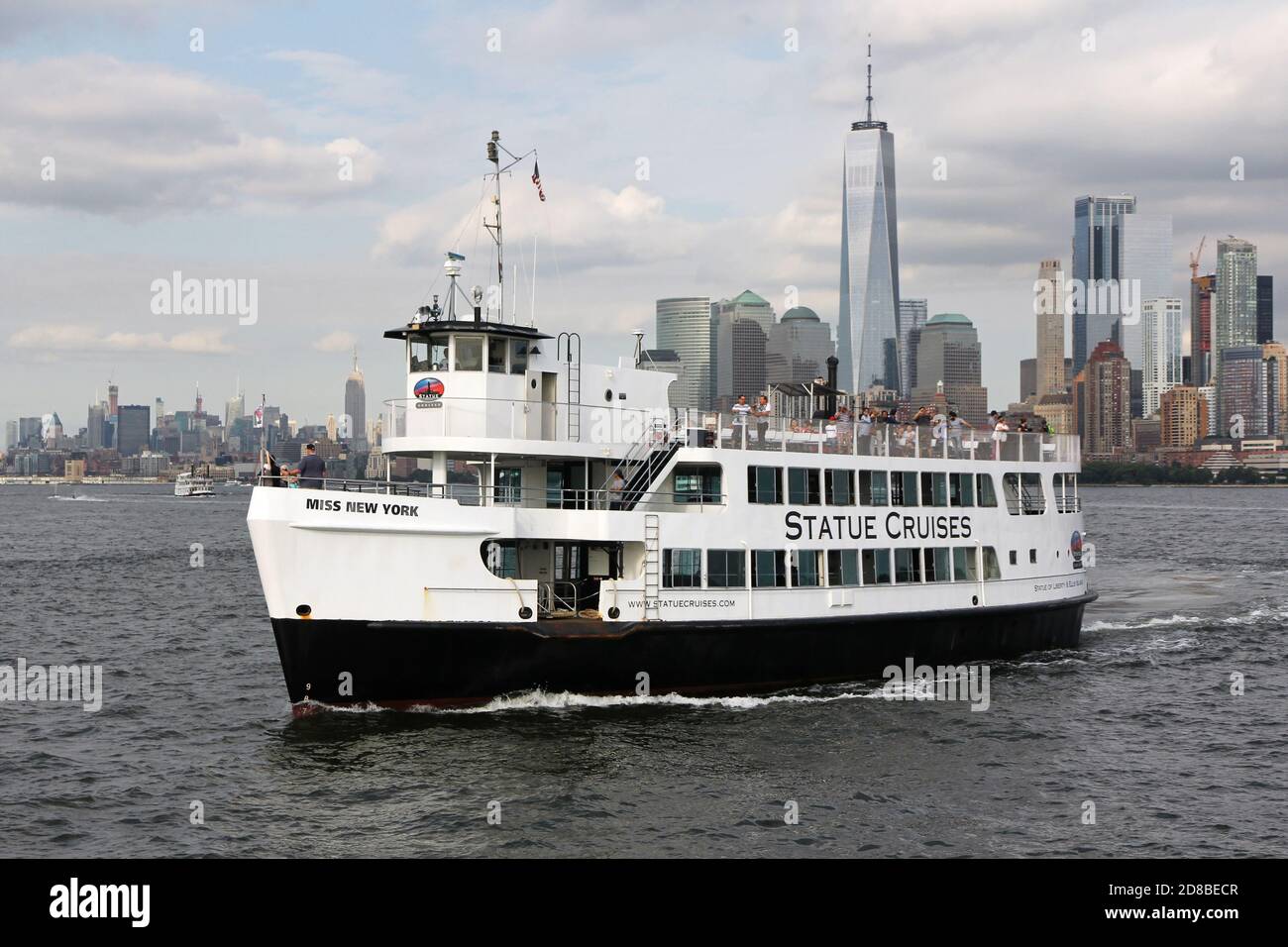 La nave "Siss New York", che porta i turisti a Libery Island ed Ellis Island, di fronte allo skyline di Manhattan Foto Stock
