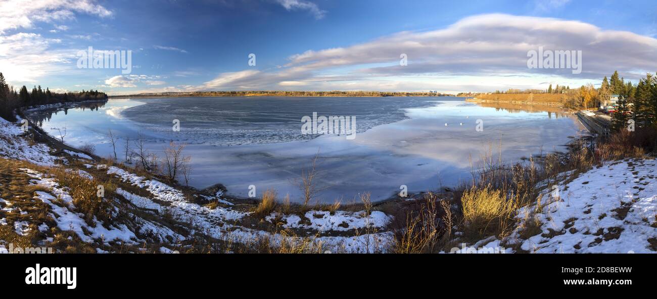 Paesaggio panoramico del lago artificiale Glenmore a South Calgary, Alberta con acqua di superficie del lago mezzo congelato con skyline del centro città all'orizzonte Foto Stock