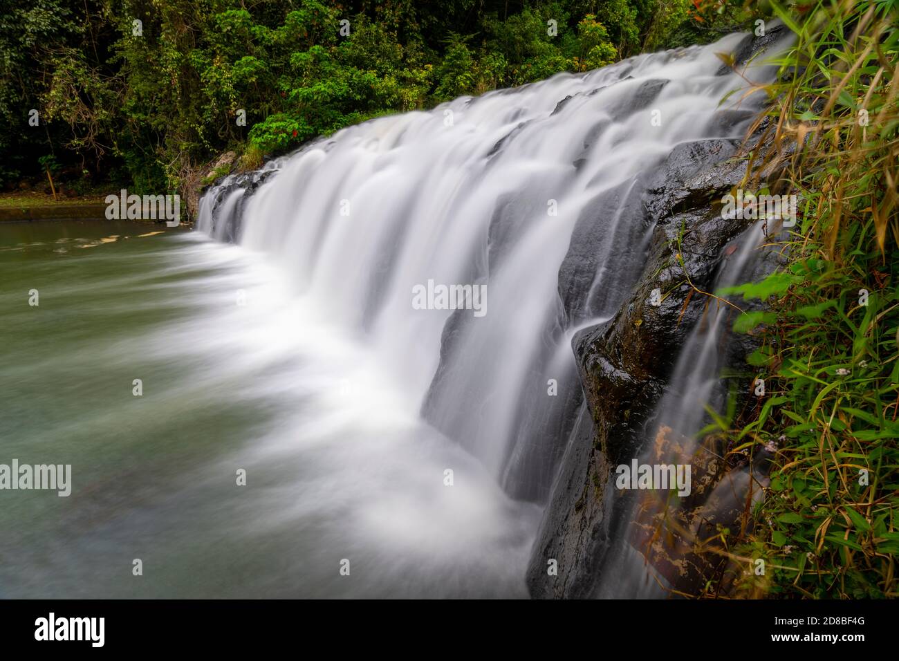 Primo piano di Malanda Falls, dove il fiume Johnstone Nord cade sopra l'antica roccia basaltica formata dal flusso lavico, Atherton Tablelands, Queensland Nord Foto Stock