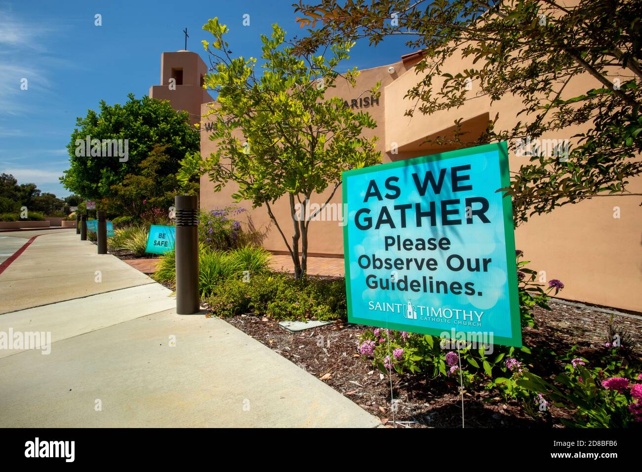 I cartelli di una chiesa cattolica della California meridionale accolgono i parrocchiani in arrivo mentre li avvertono di osservare le misure di sicurezza durante il coronavirus pand Foto Stock