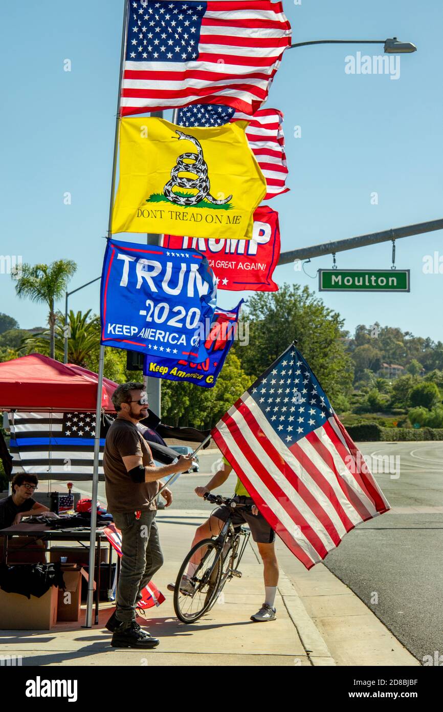 I sostenitori della rielezione di Donald Trump nel 2020 vendono striscioni, magliette e cappelli sul marciapiede a Laguna Woods, California. Foto Stock