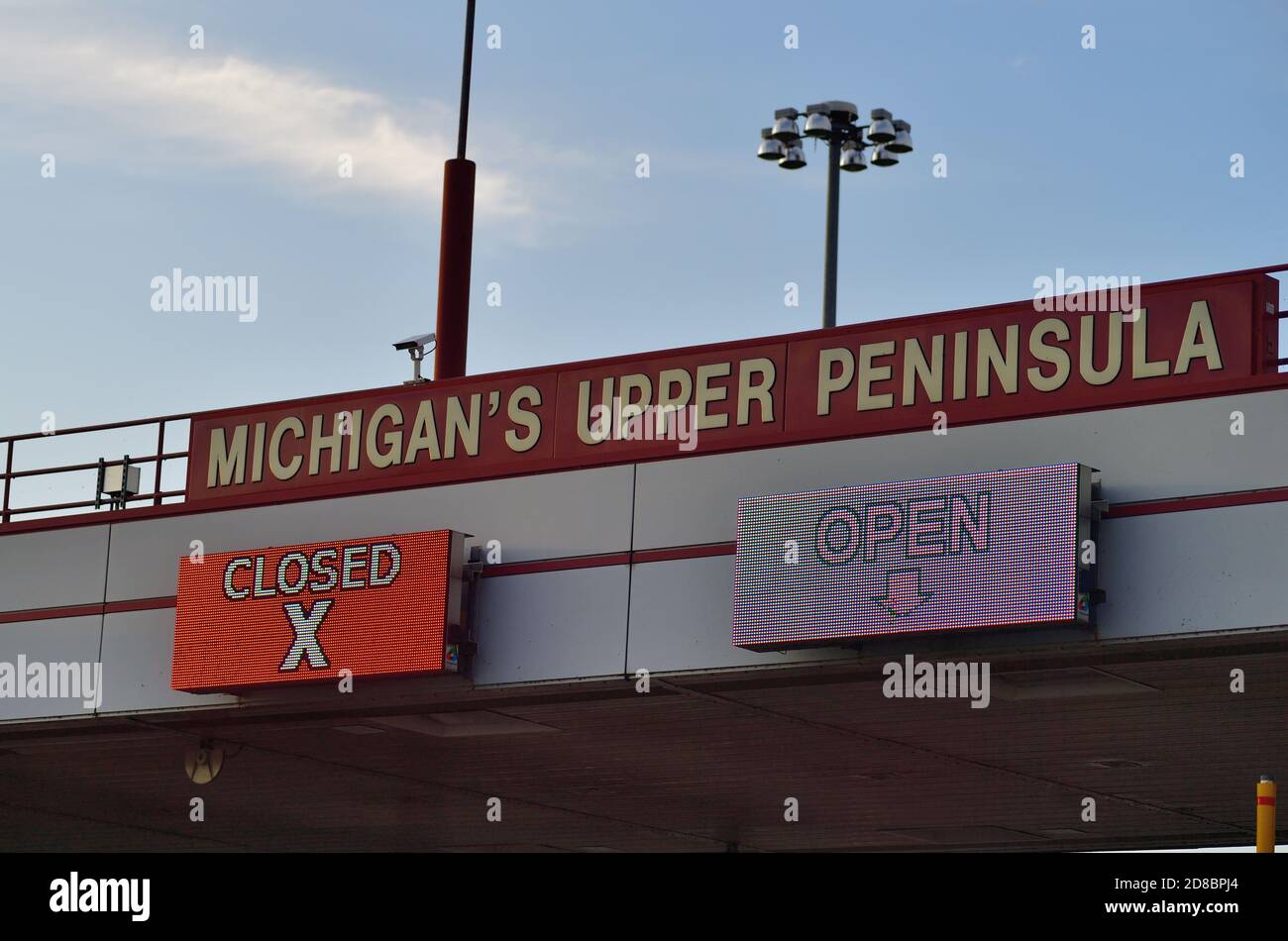St. Ignace, Michigan, Stati Uniti. Cartelli sopra i pedaggi sul Mackinac Bridge che danno il benvenuto agli automobilisti nella penisola superiore del Michigan. Foto Stock