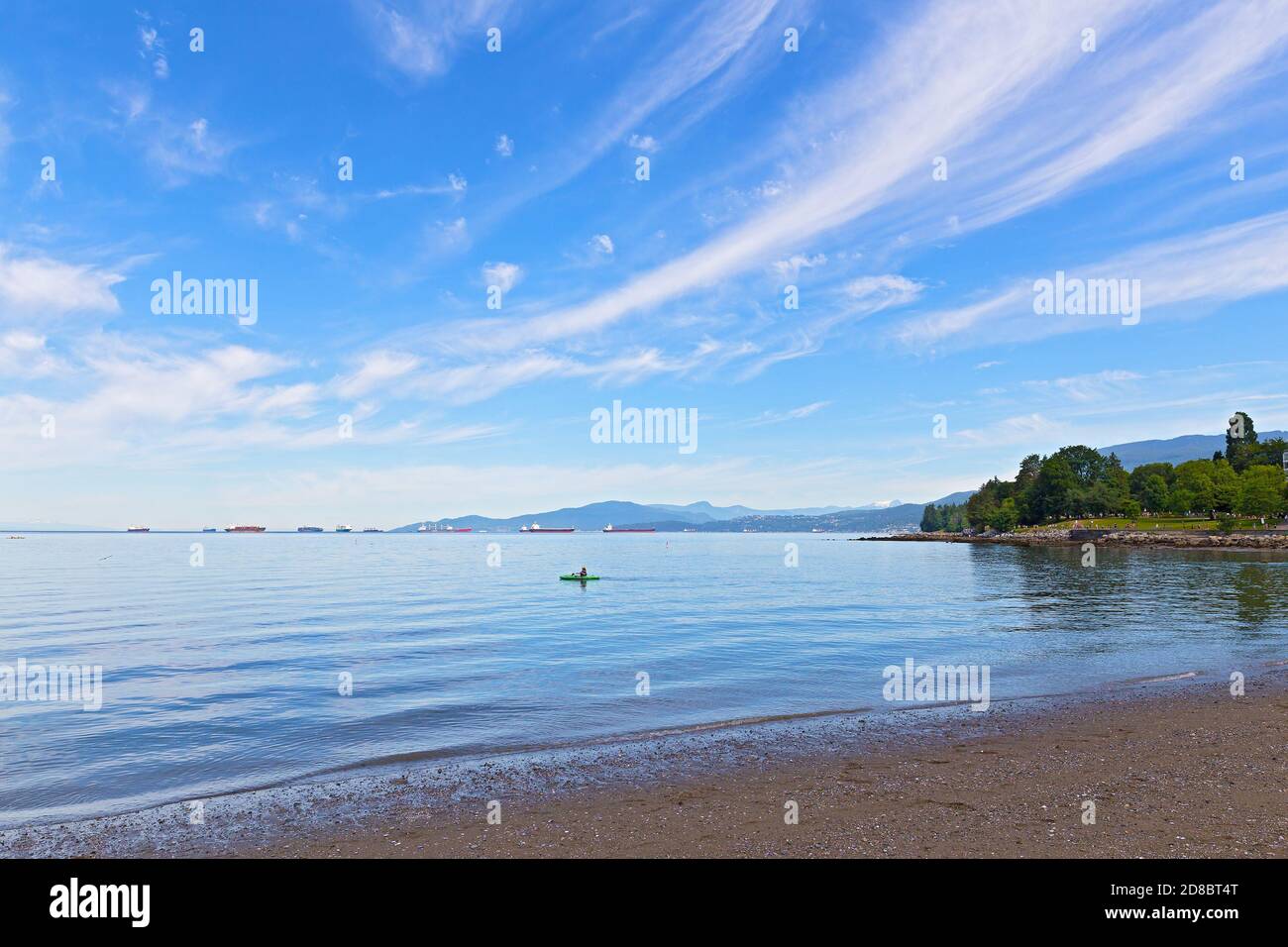 Vista panoramica della English Bay con orizzonte sull'acqua e sulle montagne, Vancouver, British Columbia, Canada. Kayak, gabbiani, imbarcazioni nautiche e neve m Foto Stock