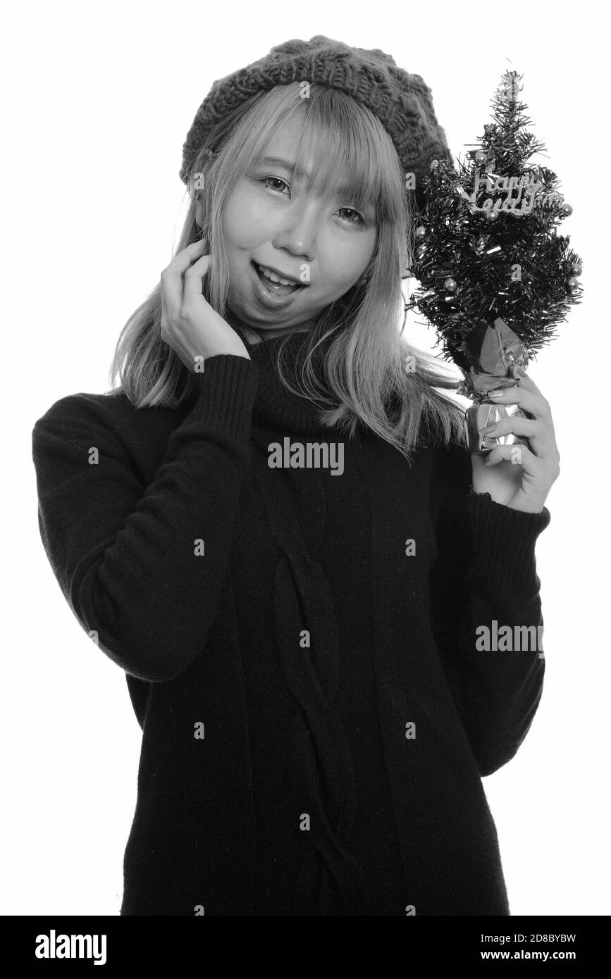 Felice giovane donna asiatica sorridente tenendo felice anno nuovo albero Foto Stock