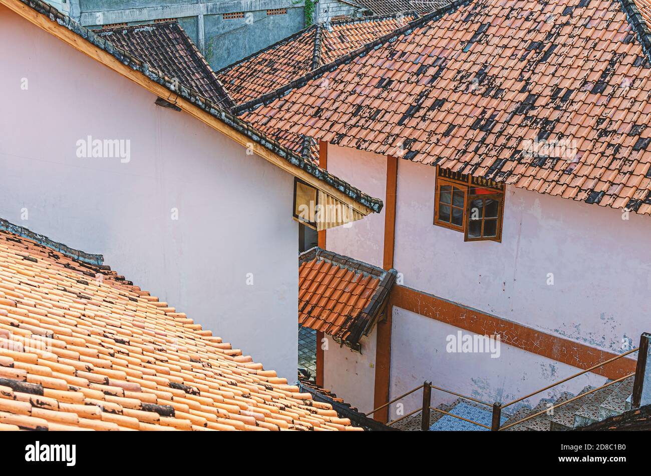 Vecchie case con tetti di tegole arancioni, strade strette. Vista dall'alto. Asia, Bali. Foto Stock