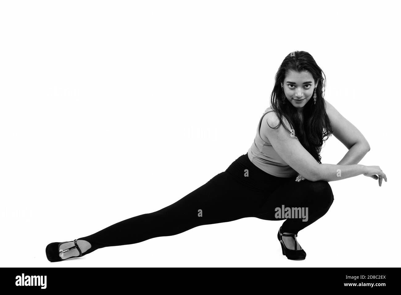 Corpo pieno colpo di giovane bella donna indiana in posa giù sul pavimento Foto Stock