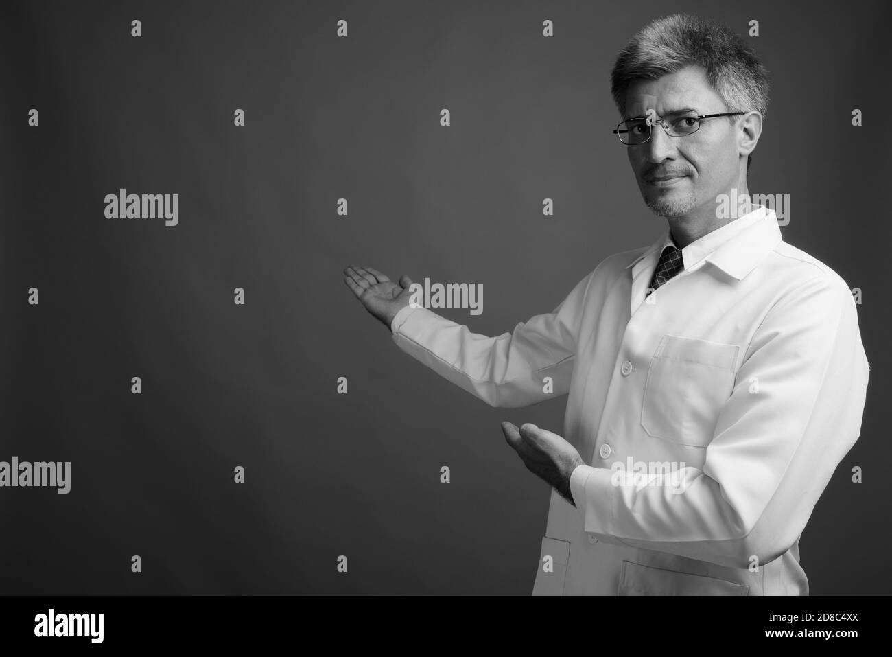 L'uomo medico con capelli biondi contro uno sfondo grigio Foto Stock
