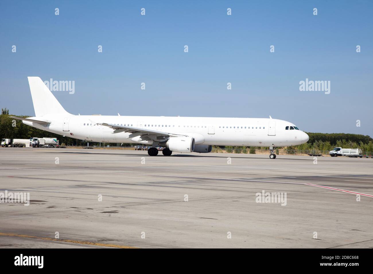 Un aereo bianco sulla pista dell'aeroporto sta tassando. Decollo e atterraggio. Arrivo e partenza. Posiziona per il testo. Mockup isolato dell'aereo del passeggero. Aereo Foto Stock