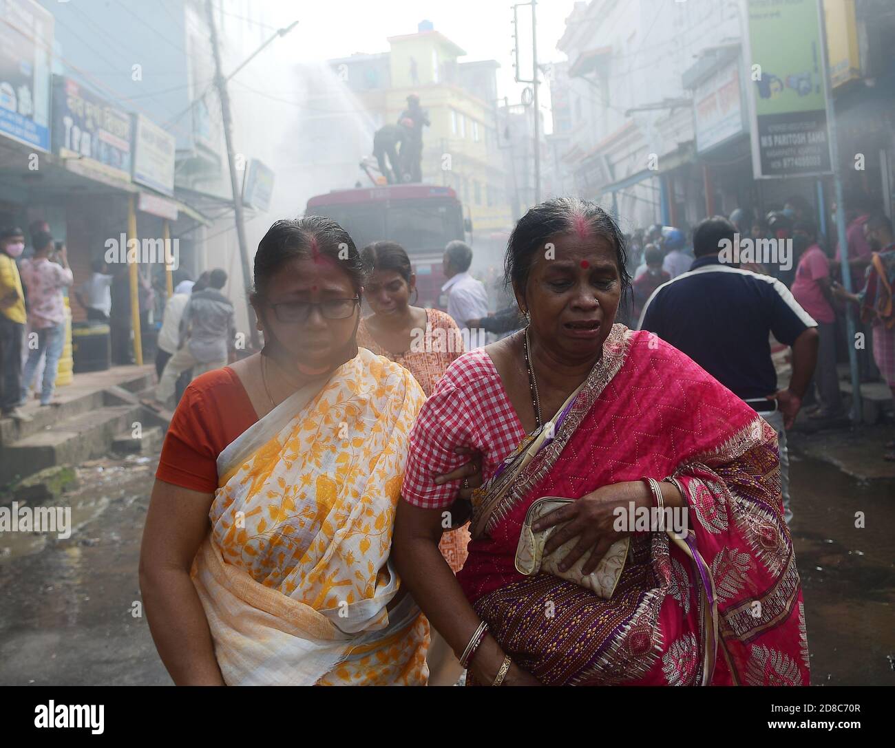 Una donna ha visto piangere di fronte a un edificio che è sul fuoco. I vigili del fuoco stanno cercando di controllare un fuoco massiccio in un supermercato. Agartala, Tripura, India. Foto Stock