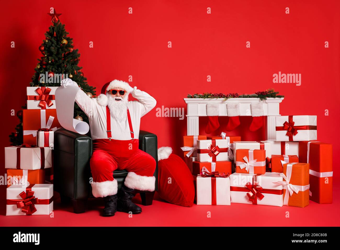 Ritratto della sua attraente funky grasso sovrappeso allegro allegria Stupito Santa seduta in poltrona leggendo lunga lettera wishlist Nord Polo isolato Foto Stock