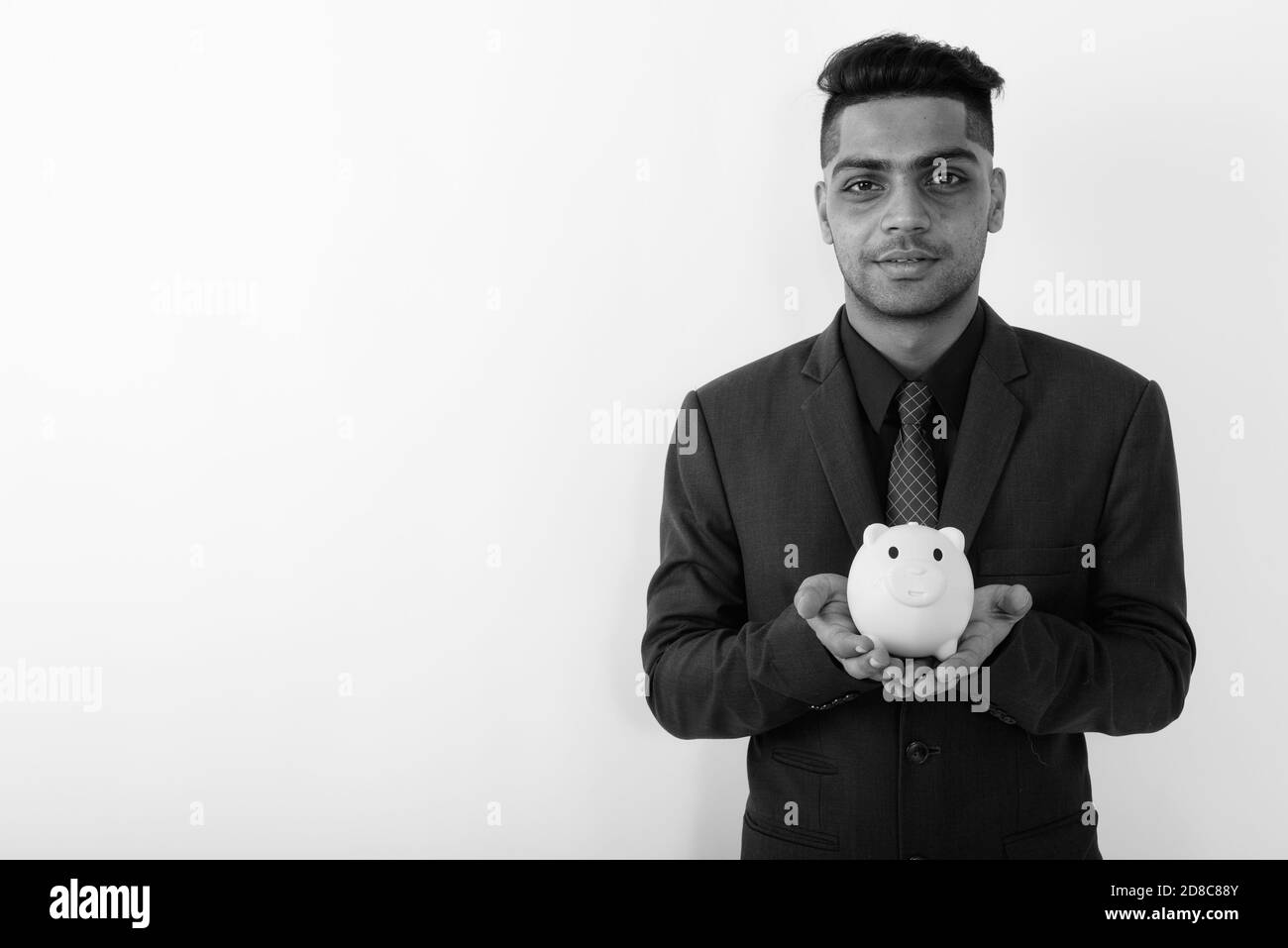 Giovane imprenditore indiano indossare tuta contro uno sfondo bianco Foto Stock