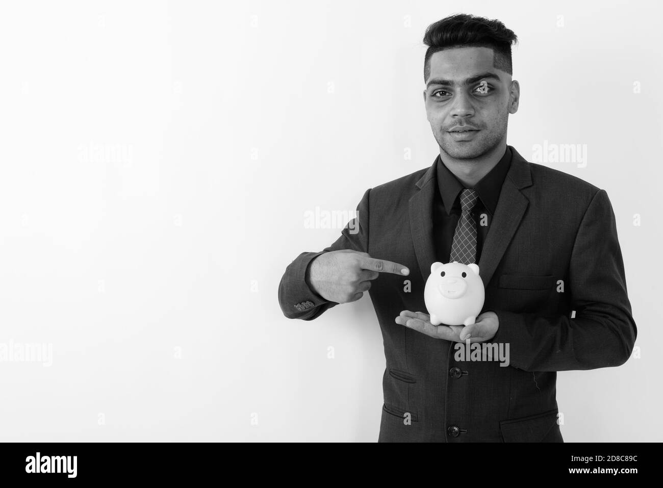 Giovane imprenditore indiano indossare tuta contro uno sfondo bianco Foto Stock
