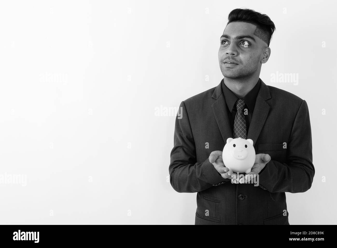 Giovane imprenditore indiano indossare tuta contro uno sfondo bianco Foto Stock