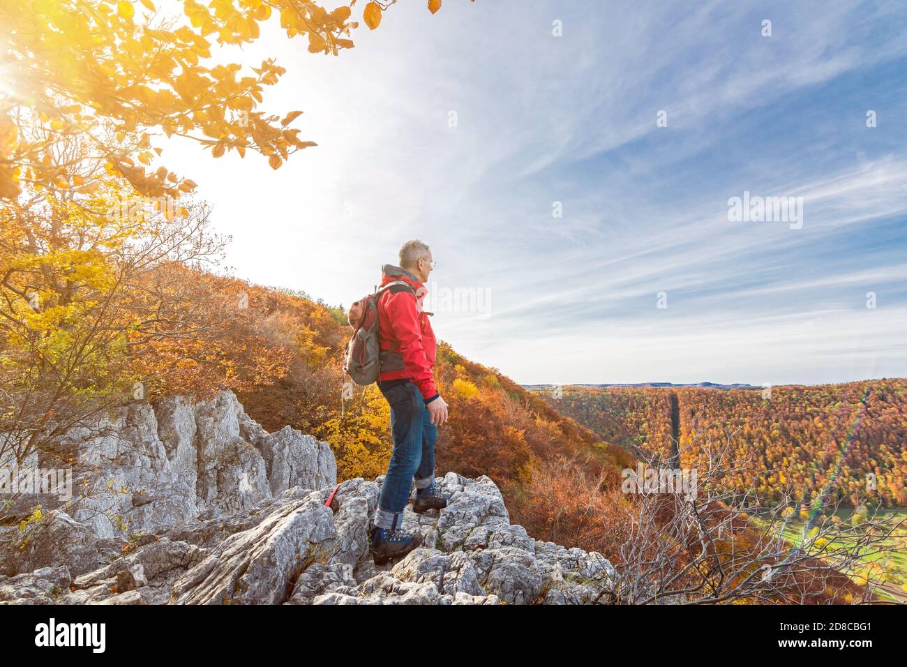 Anziano escursionista maschile in piedi su una scogliera e guardando In un colorato paesaggio collinare autunnale nel Giura svevo Foto Stock