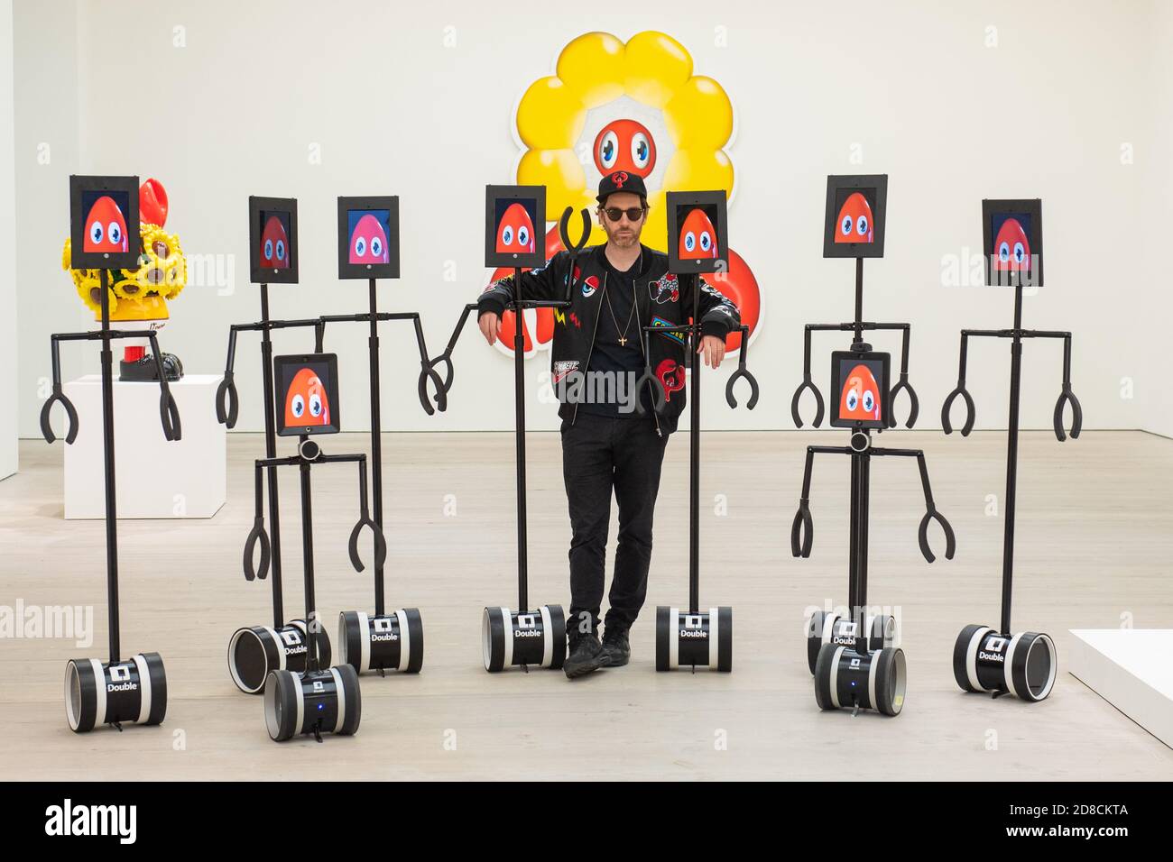 L'artista Philip Colbert con un gruppo di robot telecomandati, in un'anteprima stampa della mostra "Philip Colbert: Lobsteropolis" alla Saatchi Gallery di Londra, che offre al pubblico la possibilità di vedere opere d'arte in situ o tramite robot comodamente a casa propria. Foto Stock