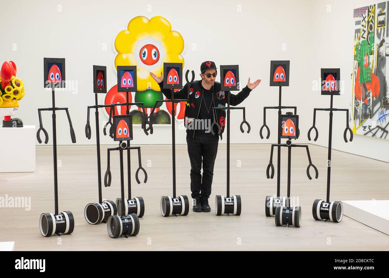 L'artista Philip Colbert con un gruppo di robot telecomandati, in un'anteprima stampa della mostra "Philip Colbert: Lobsteropolis" alla Saatchi Gallery di Londra, che offre al pubblico la possibilità di vedere opere d'arte in situ o tramite robot comodamente a casa propria. Foto Stock