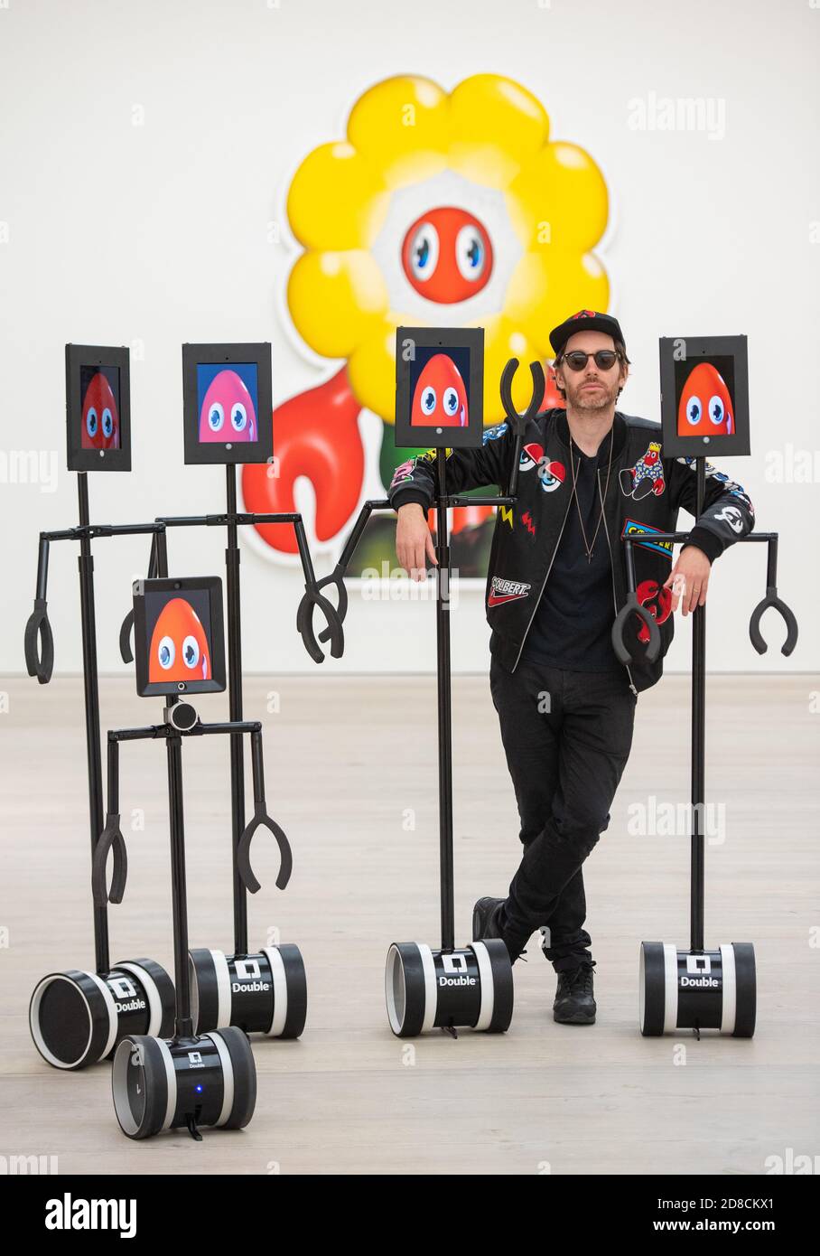 L'artista Philip Colbert con un gruppo di robot telecomandati, in un'anteprima stampa della mostra "Philip Colbert: Lobsteropolis" alla Saatchi Gallery di Londra, che offre al pubblico la possibilità di vedere opere d'arte in situ o tramite robot comodamente a casa propria. Foto Stock