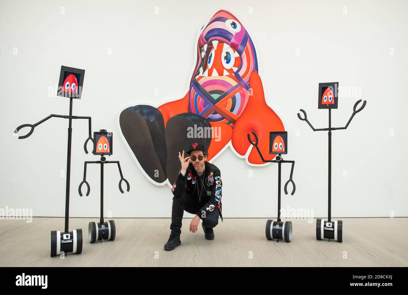 L'artista Philip Colbert con un gruppo di robot telecomandati, in un'anteprima stampa della mostra "Philip Colbert: Lobsteropolis" alla Saatchi Gallery di Londra, che offre al pubblico la possibilità di vedere opere d'arte in situ o tramite robot comodamente a casa propria. Foto Stock