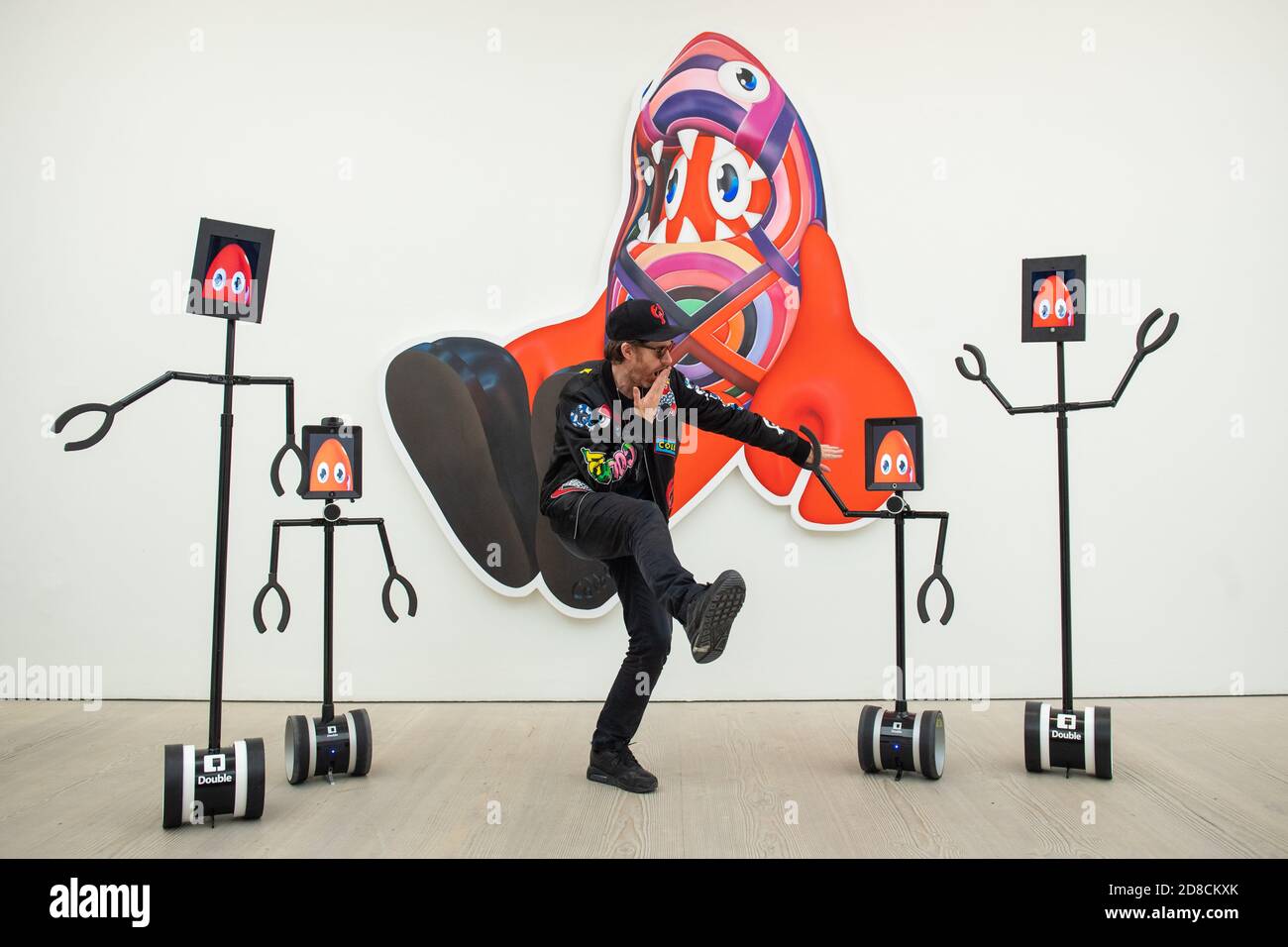 L'artista Philip Colbert con un gruppo di robot telecomandati, in un'anteprima stampa della mostra "Philip Colbert: Lobsteropolis" alla Saatchi Gallery di Londra, che offre al pubblico la possibilità di vedere opere d'arte in situ o tramite robot comodamente a casa propria. Foto Stock