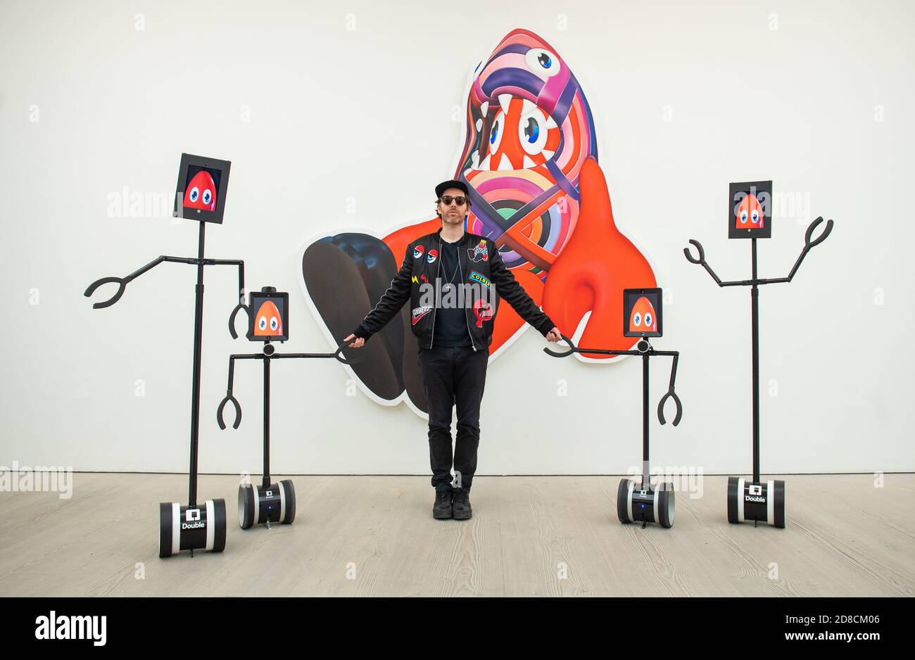 L'artista Philip Colbert con un gruppo di robot telecomandati, in un'anteprima stampa della mostra "Philip Colbert: Lobsteropolis" alla Saatchi Gallery di Londra, che offre al pubblico la possibilità di vedere opere d'arte in situ o tramite robot comodamente a casa propria. Foto Stock