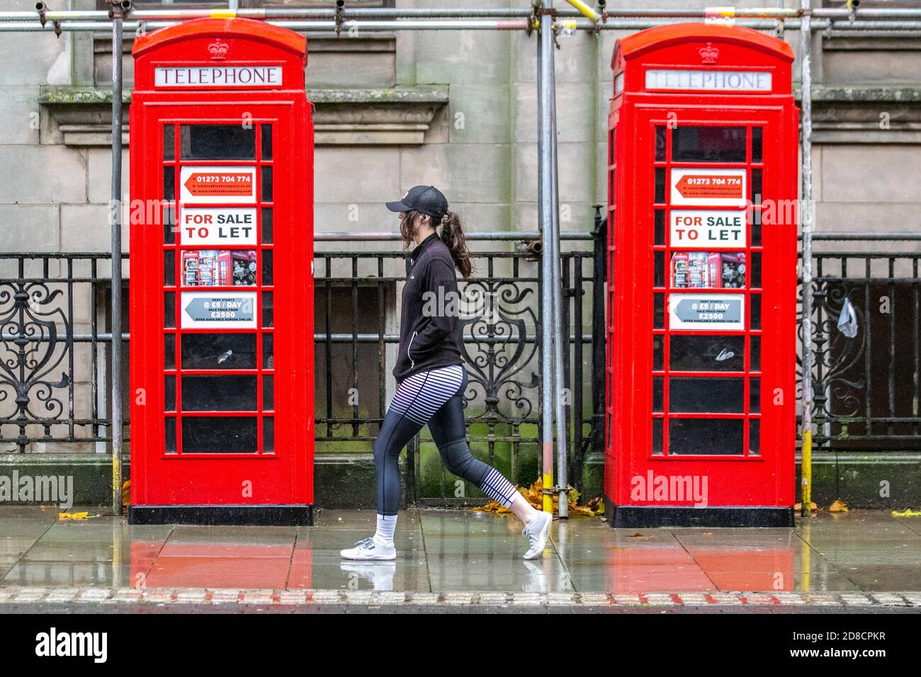 Preston, Lancashire. Regno Unito Meteo. 29 ottobre 2020. BT Telecom ha disusato K6 vecchio stile rosso chioschi di telefono per la vendita a Let; lo shopping deve andare avanti nel centro della città in una giornata bagnata piovosa con downpoours pesanti, e docce di fusione. Il settore retail di Preston è stato fortemente influenzato dalle normative Covid 19, con diverse imprese che si chiudono in alta strada. Credito; MediaWorldImages/AlamyLiveNews Foto Stock