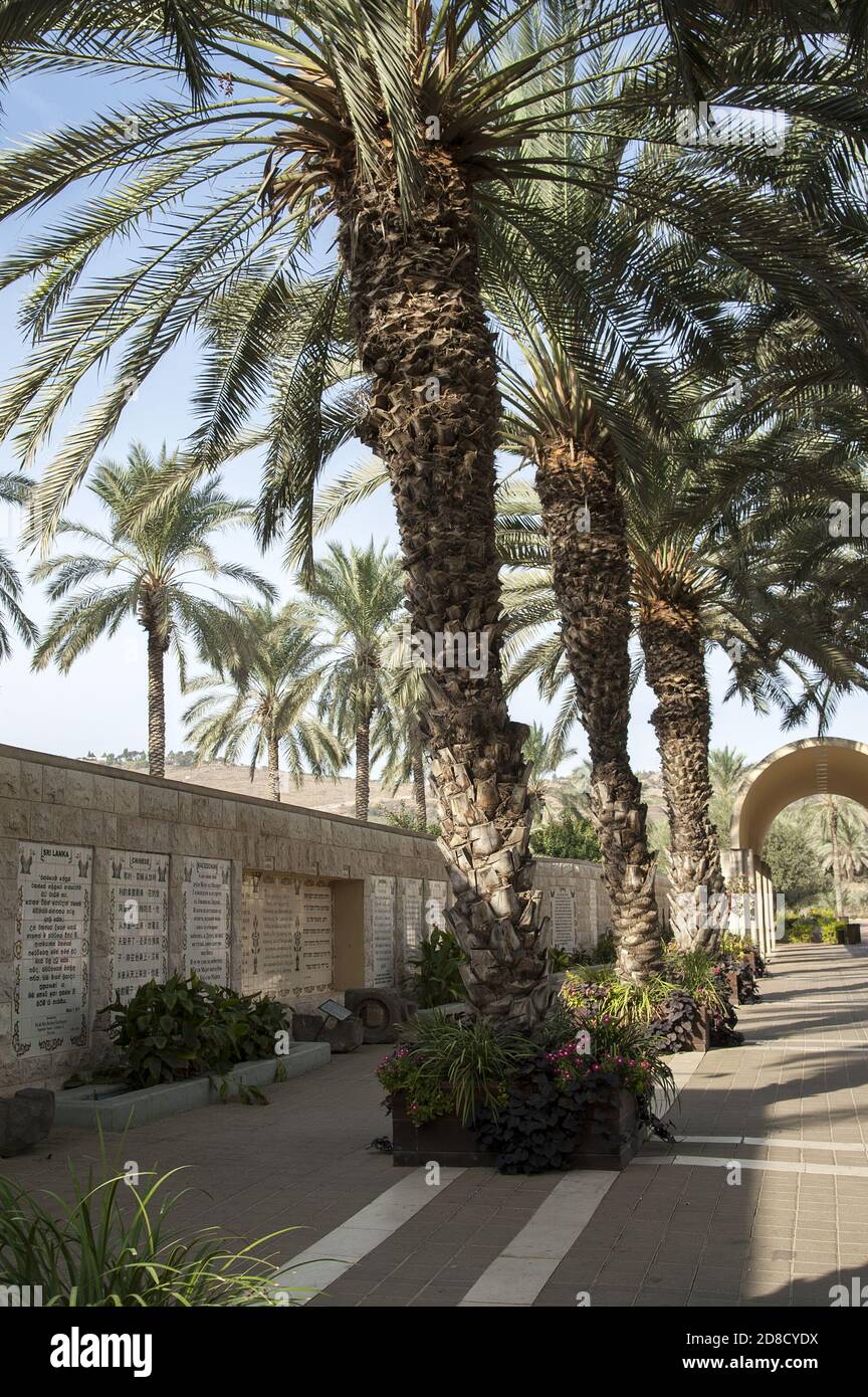 Yardenit, ירדנית, Israele, Izrael, ישראל; palme sul lungomare. Muro con tavolette con il frammento del Vangelo sul battesimo di Gesù. Foto Stock