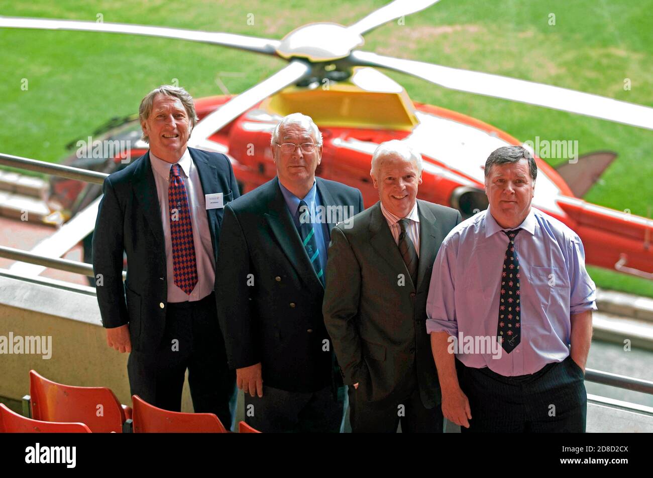 Ex rugby gallese internazionali (da sinistra) JPR Williams, John Dawes, JJ Williams e Barry John di fronte al Wales Air Ambulance Helicopter. Foto Stock