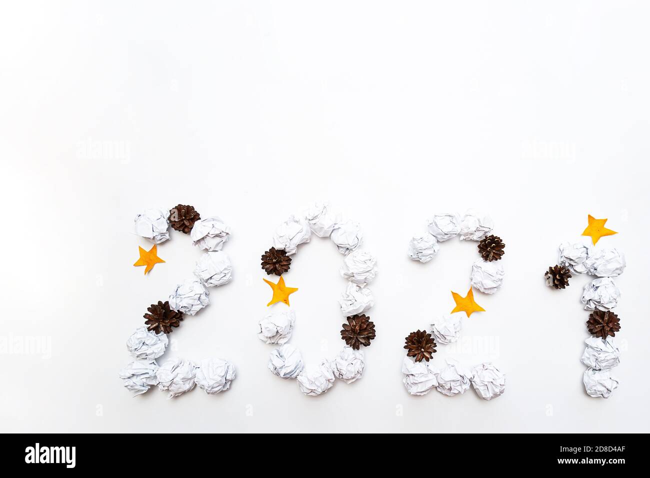 2021 figure da sminuzzate in una sfera di carta bianca, coni di pino e stelle su uno sfondo bianco. Concetto di anno nuovo Foto Stock