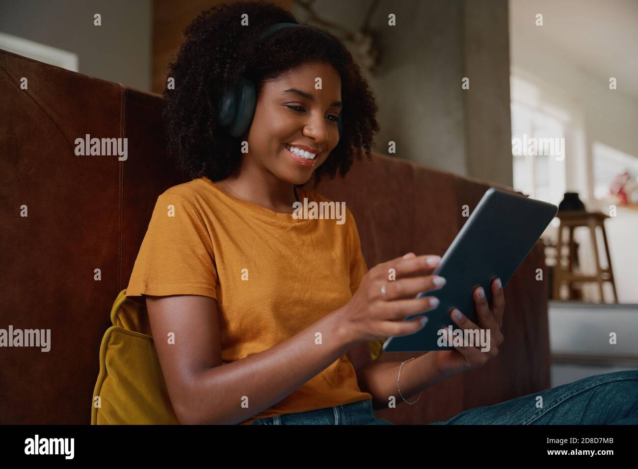 Giovane donna africana che si rilassa a casa guardando video in digitale tablet a casa Foto Stock