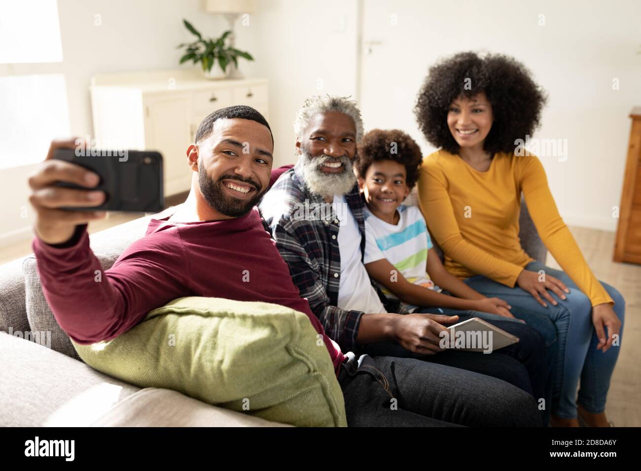 Famiglia di più generazioni che prende un selfie a casa Foto Stock