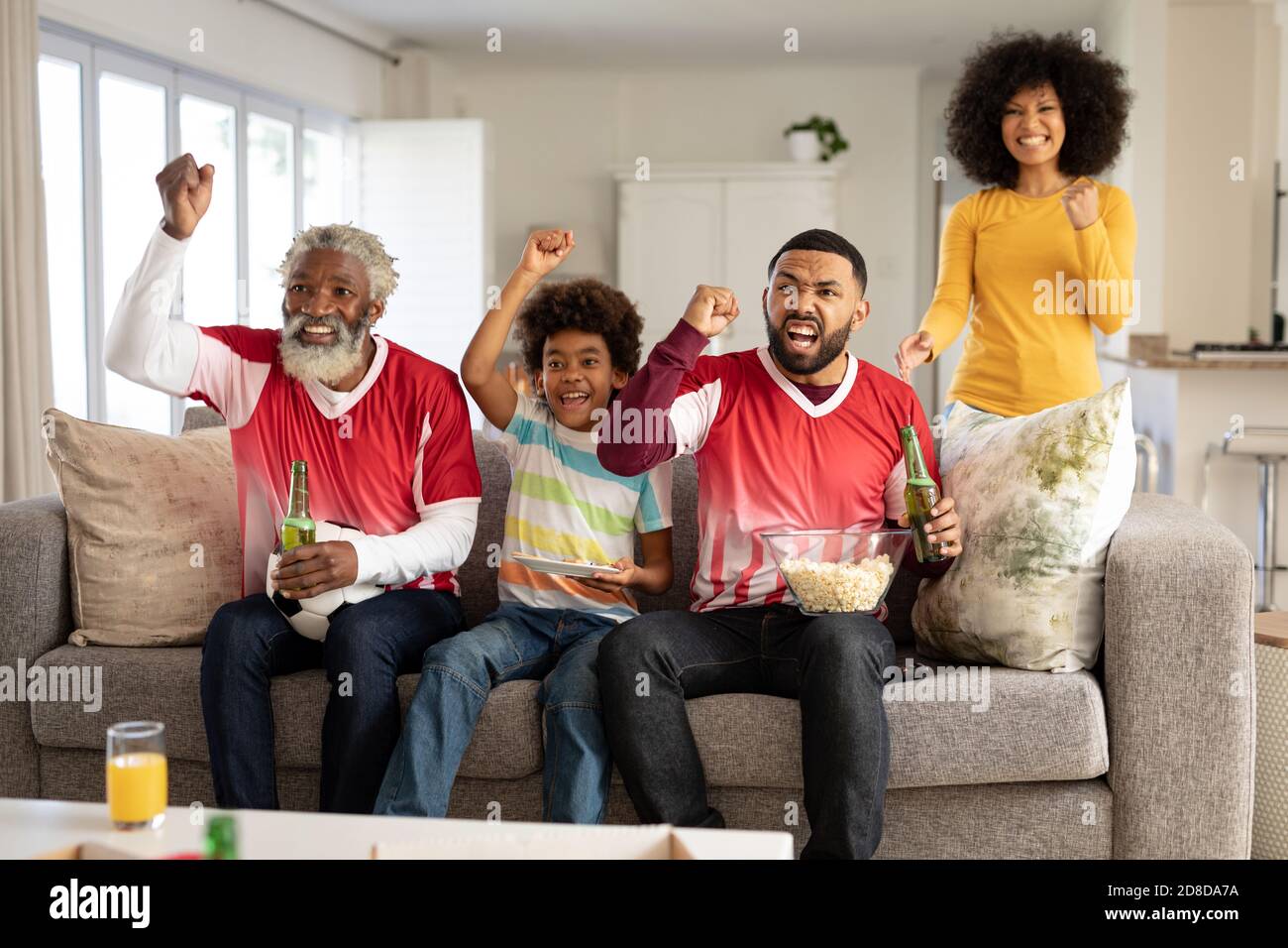 Un'allegria per tutta la famiglia durante la visione di eventi sportivi in TV Foto Stock