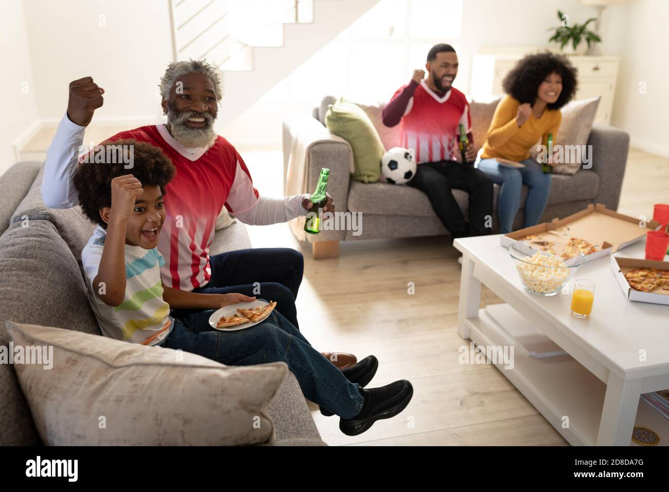 Un'allegria per tutta la famiglia durante la visione di eventi sportivi in TV Foto Stock