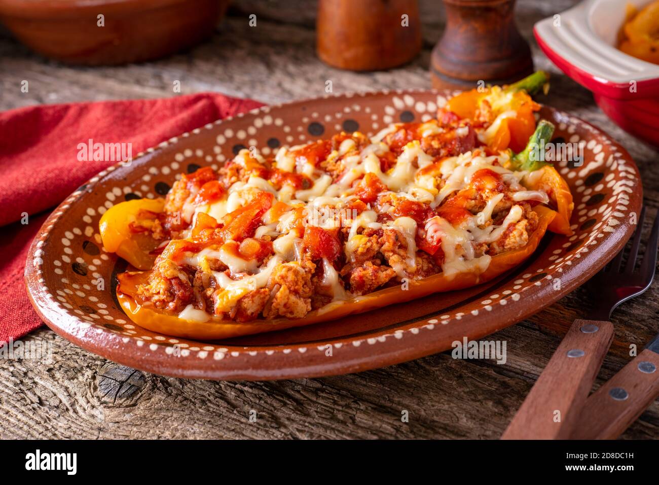 Un piatto di deliziosi peperoni ripieni in stile messicano con carne macinata, salsa di pomodoro e formaggio fuso. Foto Stock