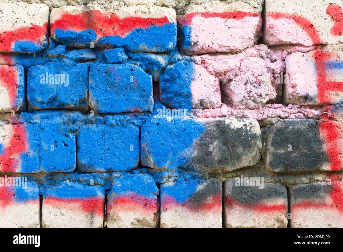 Un dettaglio graffiti su una parete ruvida in mattoni non rifiniti. Arte di strada sul muro. Foto Stock