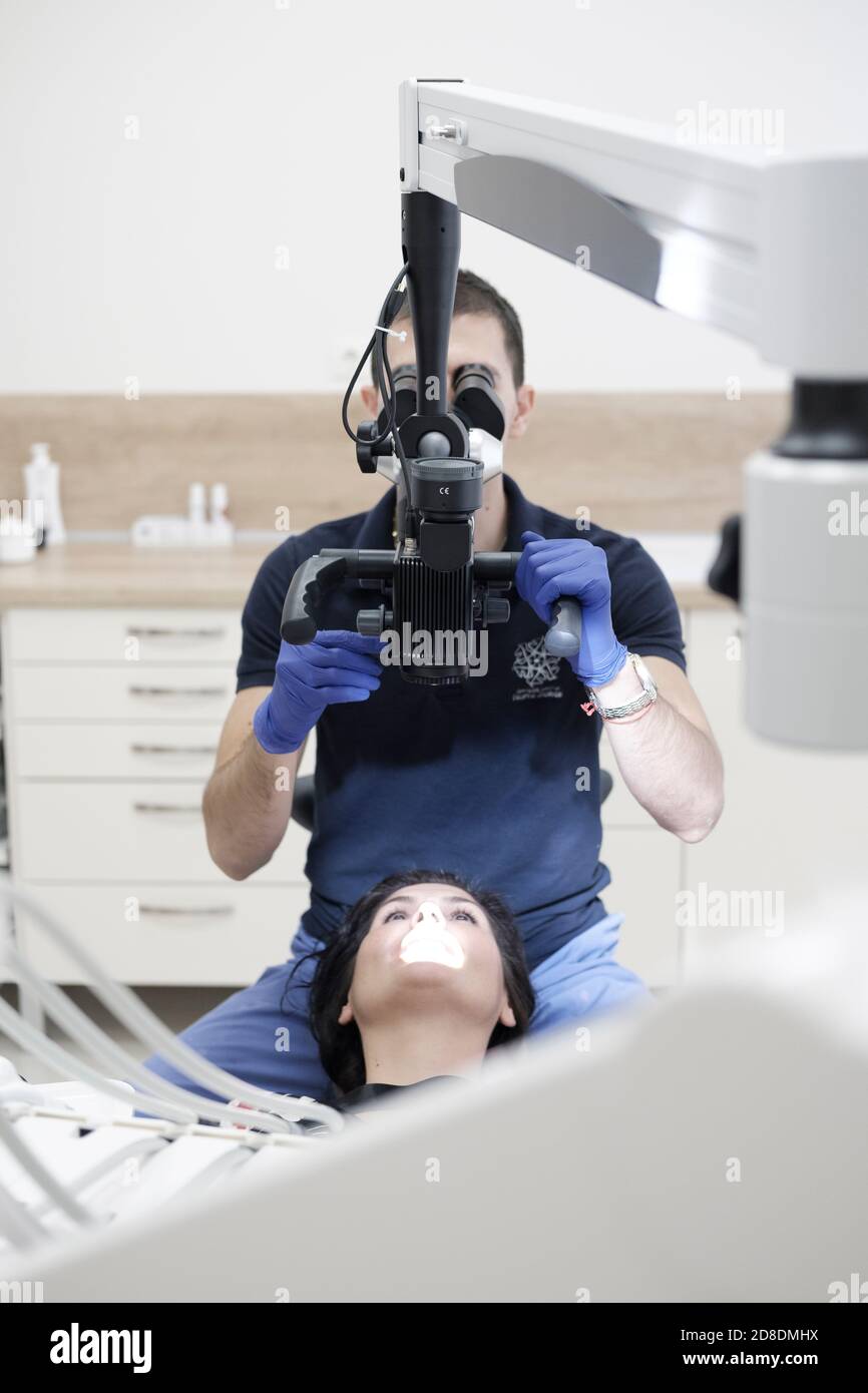 Dentista che lavora con il microscopio dentale Foto Stock
