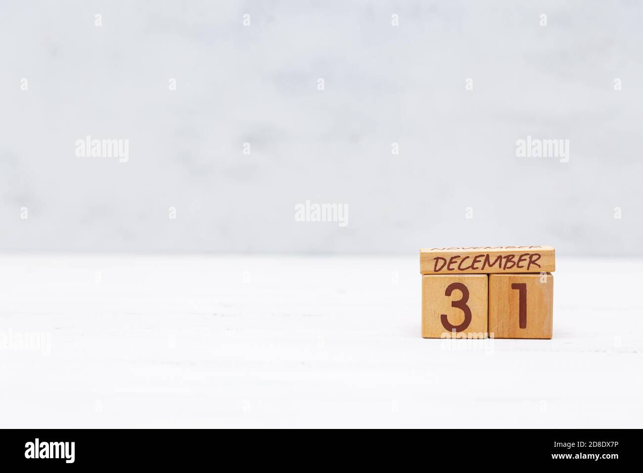 Calendario a partire da cubi di legno con la data di dicembre 31 su sfondo grigio chiaro. Anno nuovo, fine anno, festa, vigilia. Spazio di copia. Foto Stock