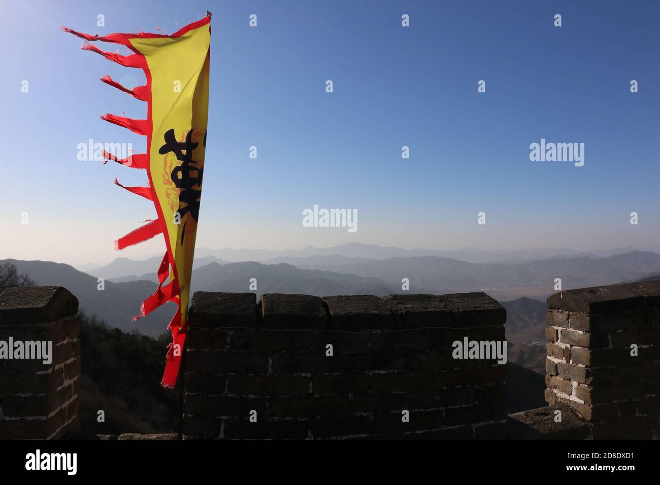 Bandiera gialla e rossa della dinastia Han che sorvola le merlature Sulla Grande Muraglia della Cina a Mutianyu Foto Stock