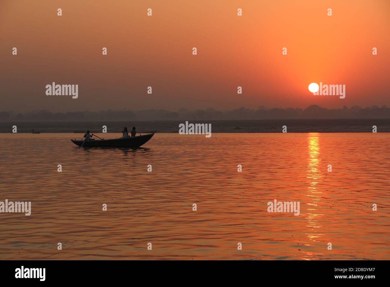 Figure dalle silhouette in una barca sul Gange al tramonto Foto Stock