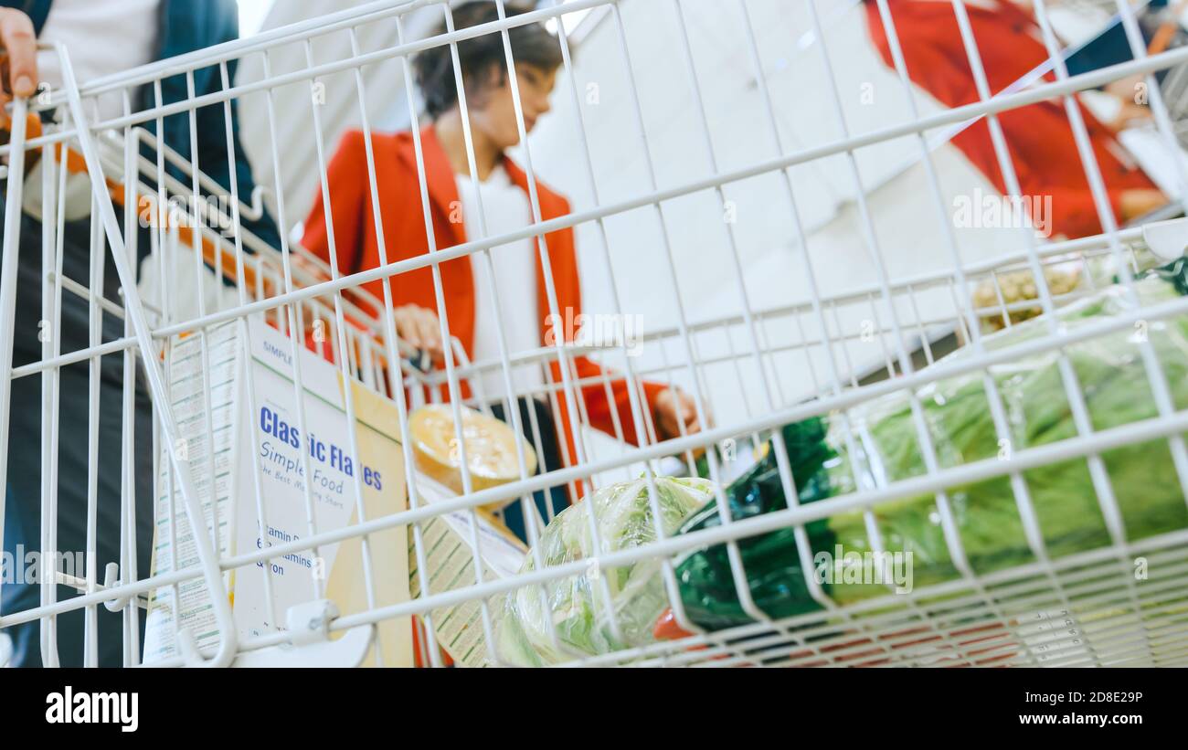 Al supermercato: La coppia sposata sceglie frutta biologica nella sezione prodotti freschi del mercato agricolo. Raccolano la frutta e la mettono dentro Foto Stock