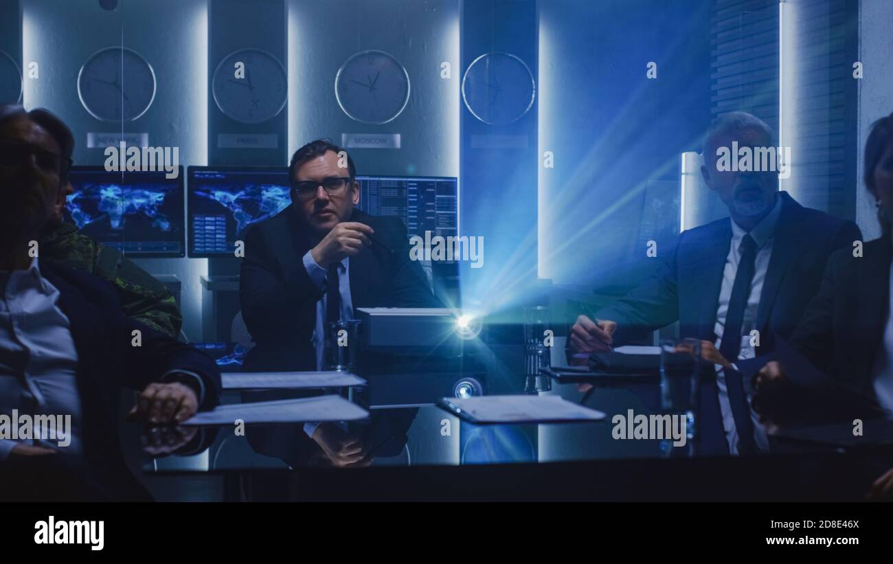 Funzionari governativi, militari e dirigenti aziendali di alto livello che guardano la presentazione nella Sala conferenze. Proiettore di lavoro sul tavolo. Foto Stock