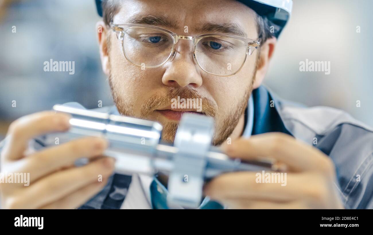 Primo piano delle classi di usura degli ingegneri industriali e Hard Hat collega due componenti progettati. Precisione nella progettazione meccanica. Foto Stock
