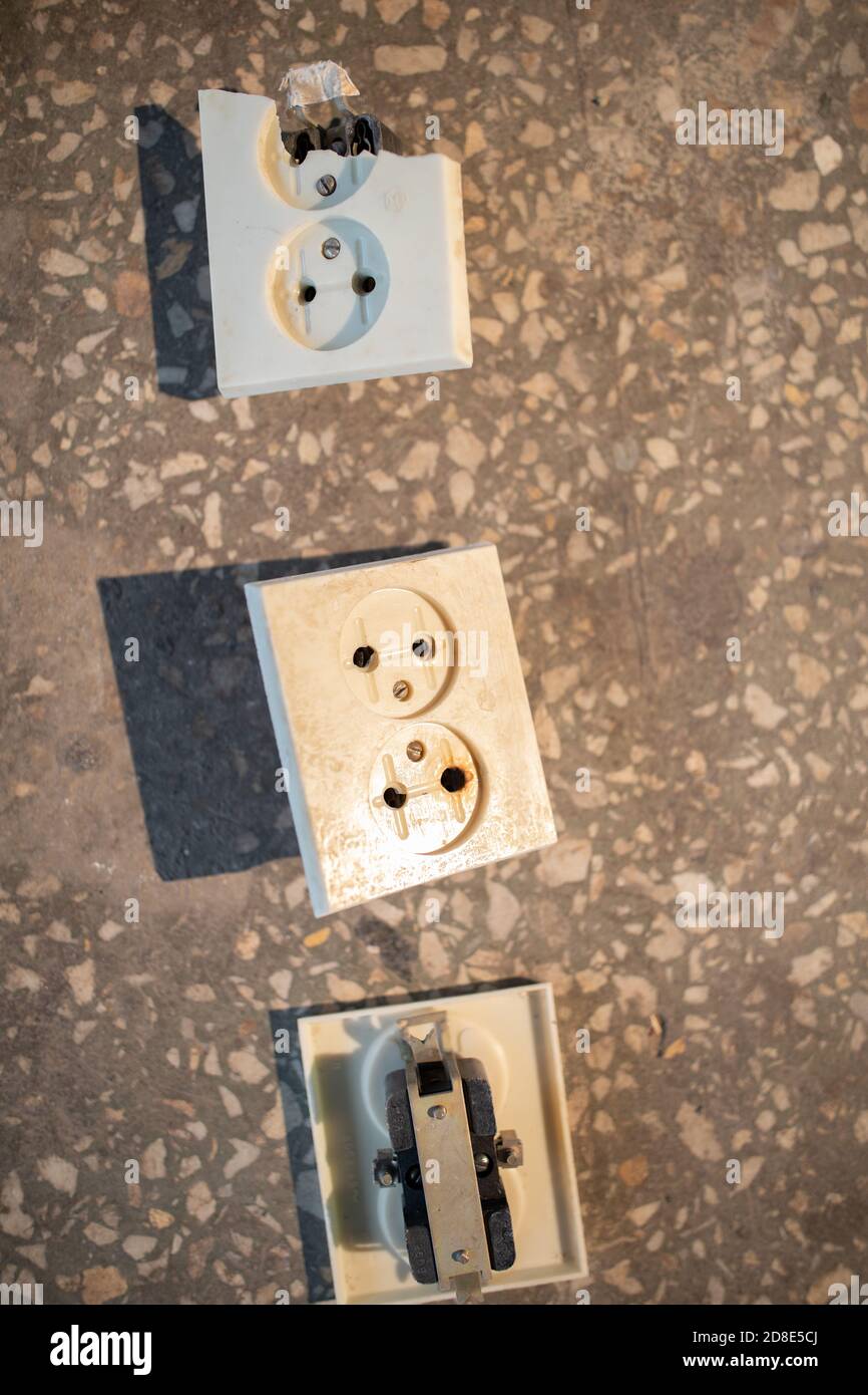 La vecchia presa elettrica rotta è caduta dalla parete. Foto Stock