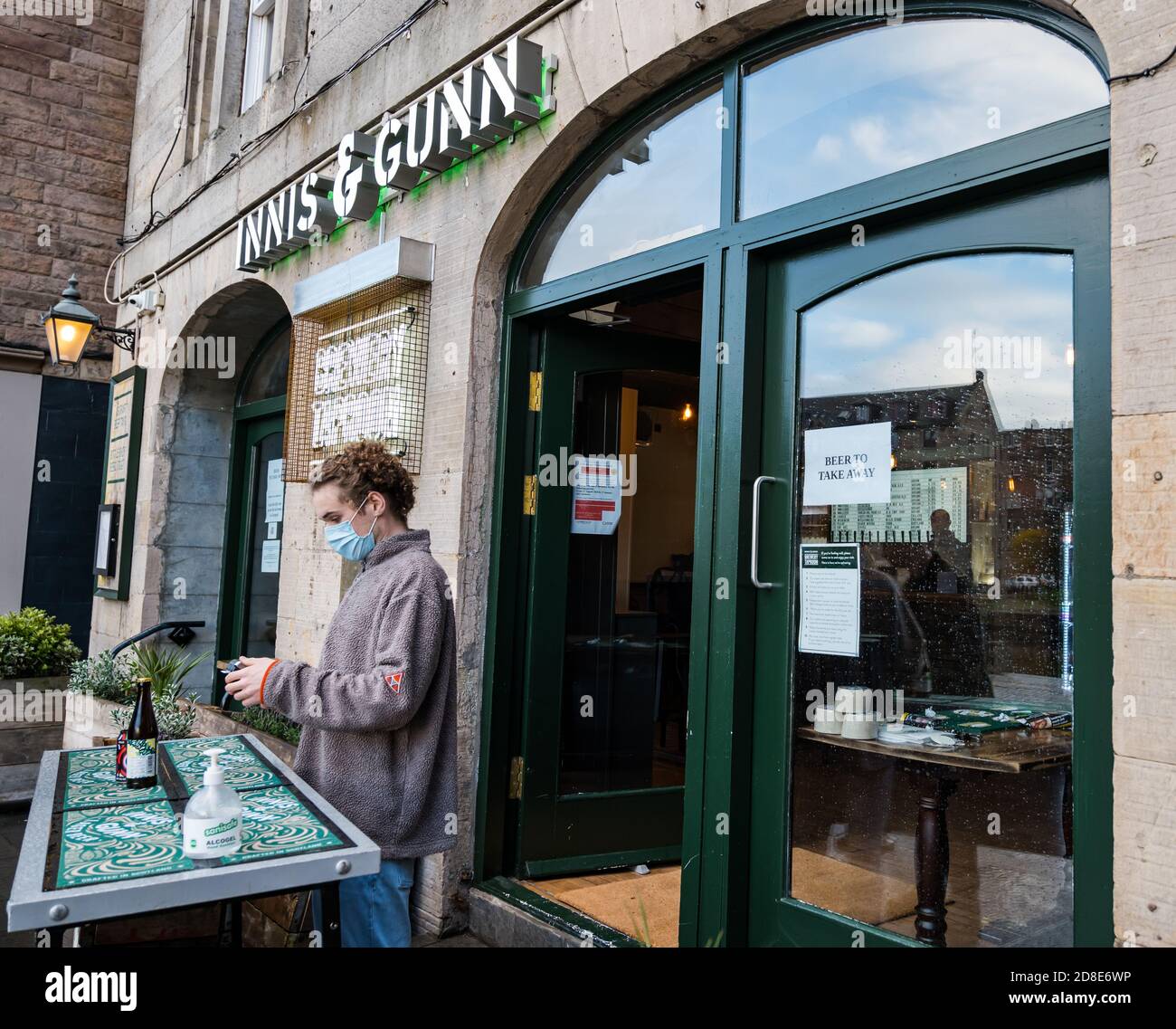 Il membro del personale indossa una maschera al pub Innis & Gunn Brewery Taproom durante le restrizioni Covid-19, The Shore, Leith, Edinburgh, Scotland, UK Foto Stock