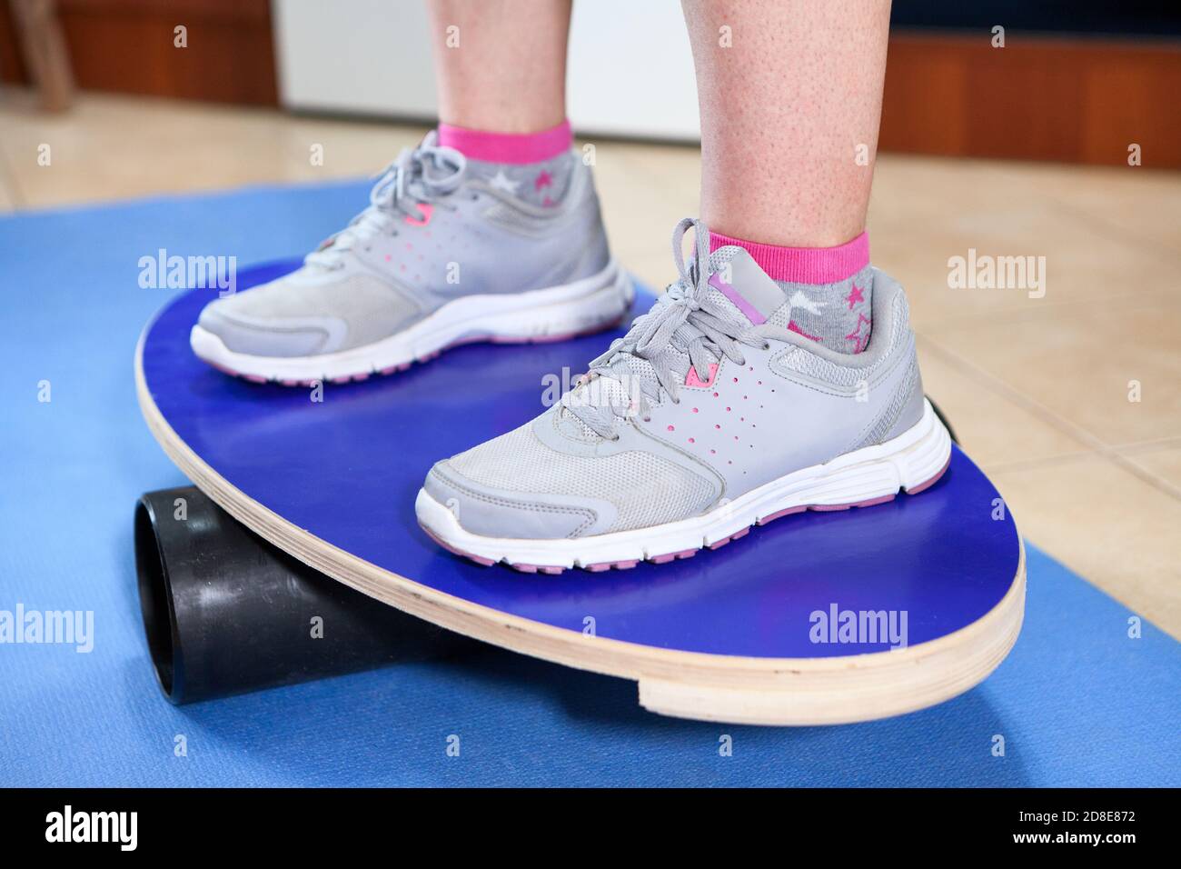 Piedi umani in scarpe da jogging in piedi su una tavola di bilanciamento Foto Stock